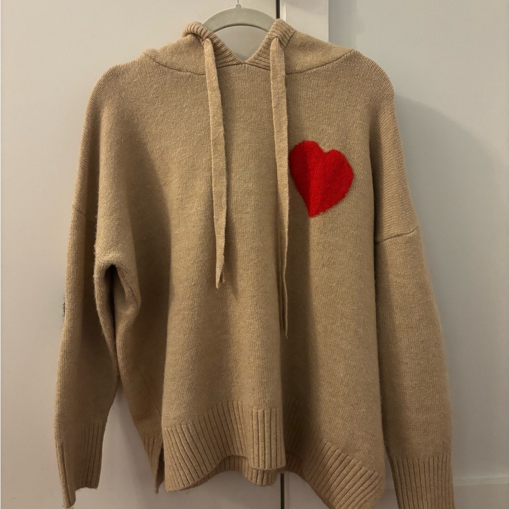 Beige hooded sweater with red heart and black hearts on elbows.